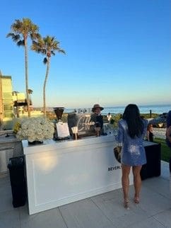 A woman standing at the bar of an outdoor event.