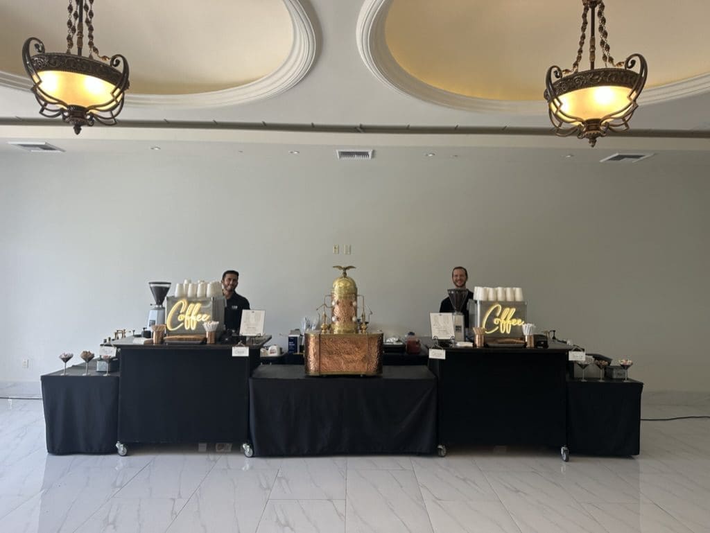 A couple of people sitting at tables with food.