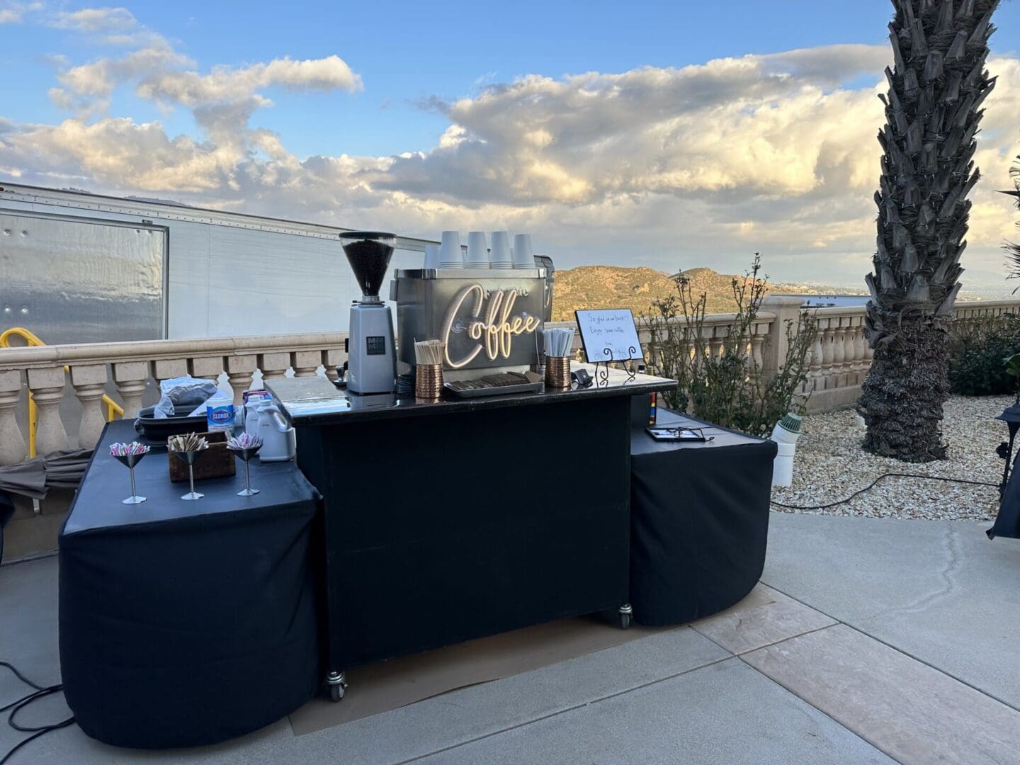 A table with a coffee maker and other items on it.